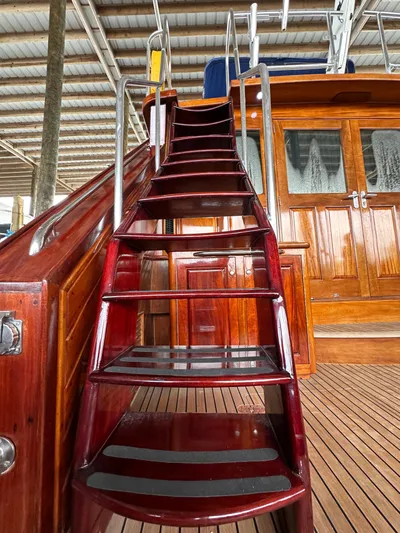 Liberty Belle Yacht Photos Pics Staircase on 1980 Bertram 58 Convertible Custom yacht with polished wood finish.