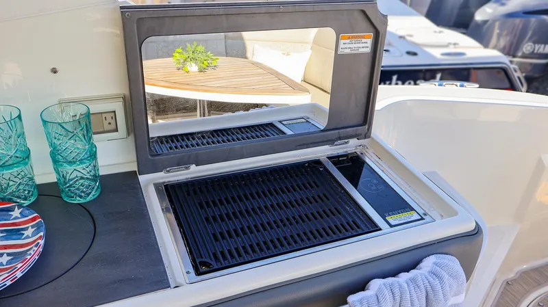 4743jg Yacht Photos Pics Outdoor grill on 2021 Sea Ray 320 Sundancer yacht with glassware and towel.
