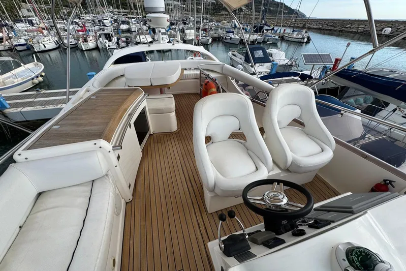 My Law Yacht Photos Pics 2007 Fairline Phantom 48 yacht interior with white seating and wooden deck in marina.