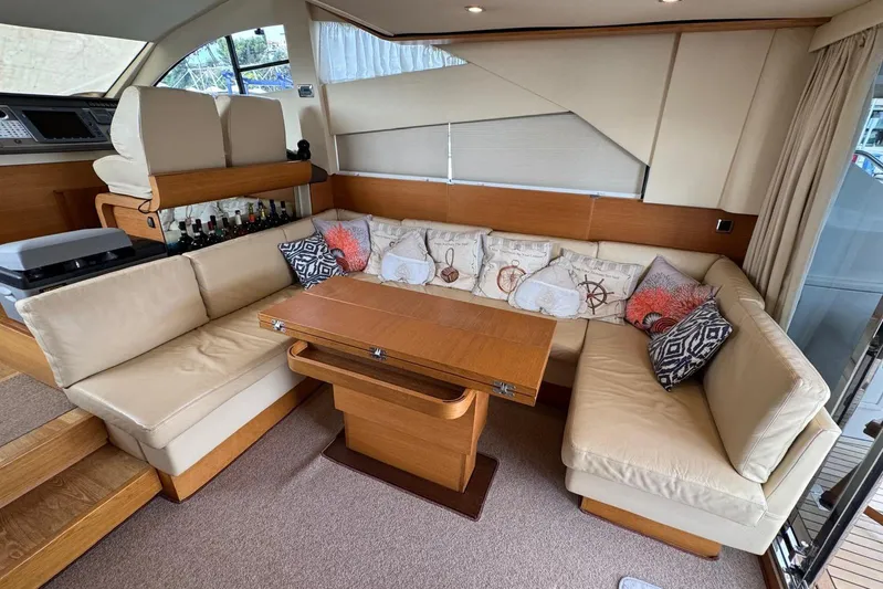 My Law Yacht Photos Pics Luxurious interior of 2007 Fairline Phantom 48 yacht with beige leather seating and wooden table.