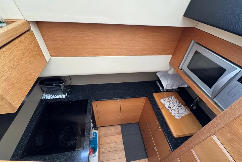 My Law Yacht Photos Pics 2007 Fairline Phantom 48 yacht kitchen with stove, microwave, and wooden cabinetry.