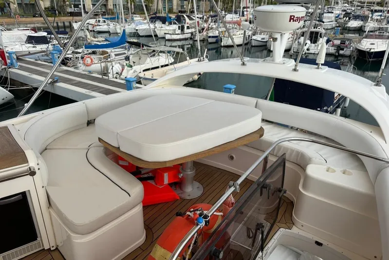 My Law Yacht Photos Pics 2007 Fairline Phantom 48 yacht interior with cushioned seating and table, docked at marina.