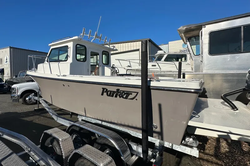  Yacht Photos Pics 2026 Parker 227 Explorer boat on trailer, parked outdoors under clear blue sky.