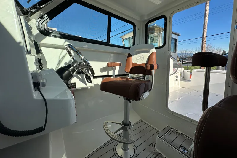  Yacht Photos Pics Interior of 2026 Parker 227 Explorer boat with captain's chair and steering wheel.