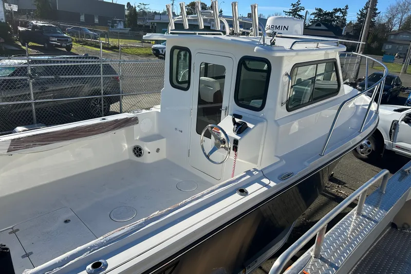  Yacht Photos Pics 2026 Parker 227 Explorer boat with enclosed cabin, docked outdoors.