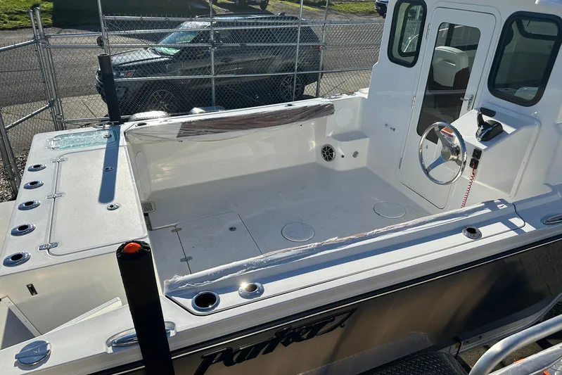  Yacht Photos Pics 2026 Parker 227 Explorer boat interior with steering wheel and seating area.