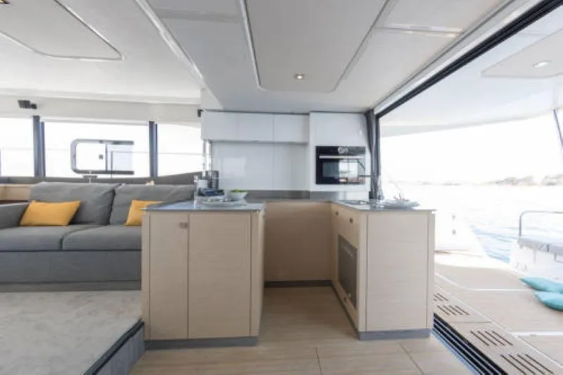 Mona Lisa Yacht Photos Pics Modern interior of 2024 Fountaine Pajot MY.6 yacht with kitchen and lounge area.