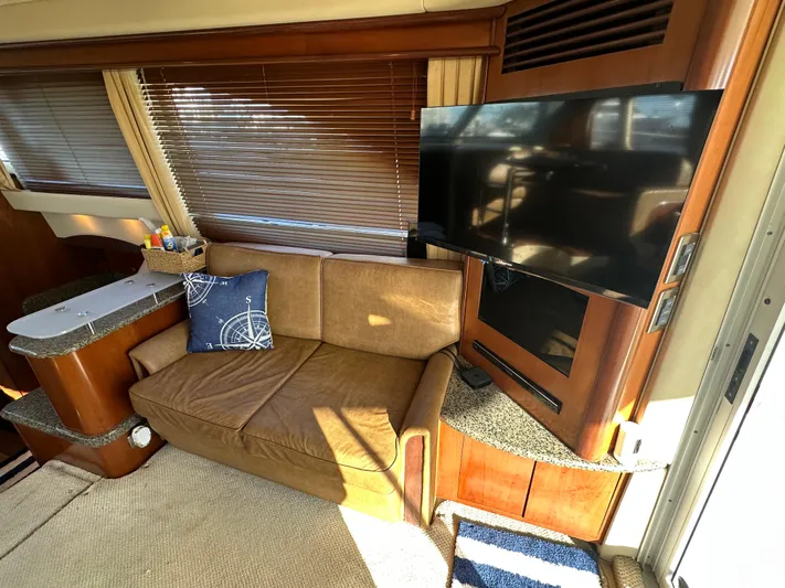  Yacht Photos Pics Interior of 2005 Sea Ray 420 Sedan Bridge with sofa, TV, and wooden accents.