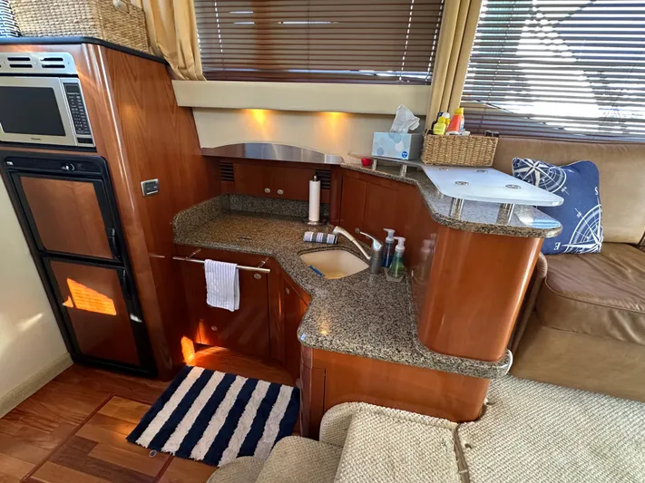  Yacht Photos Pics Interior of 2005 Sea Ray 420 Sedan Bridge with modern kitchen and cozy seating area.