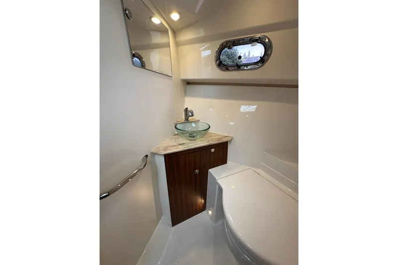  Yacht Photos Pics 2018 Pursuit OS 325 Offshore bathroom with modern sink and porthole window.