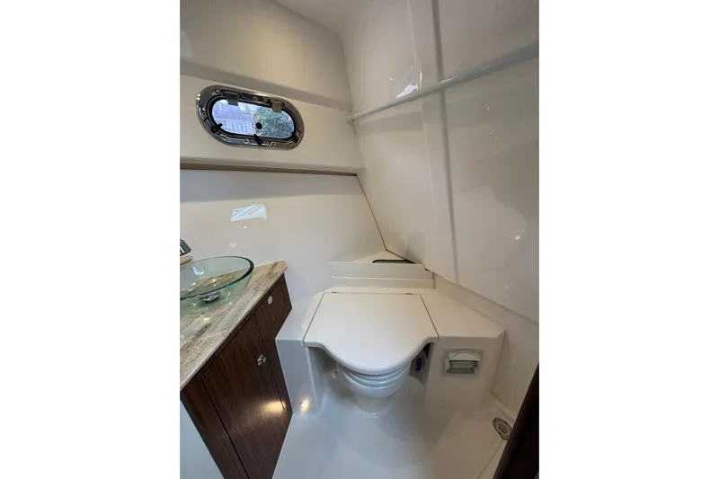  Yacht Photos Pics 2018 Pursuit OS 325 Offshore boat bathroom with modern fixtures and porthole window.