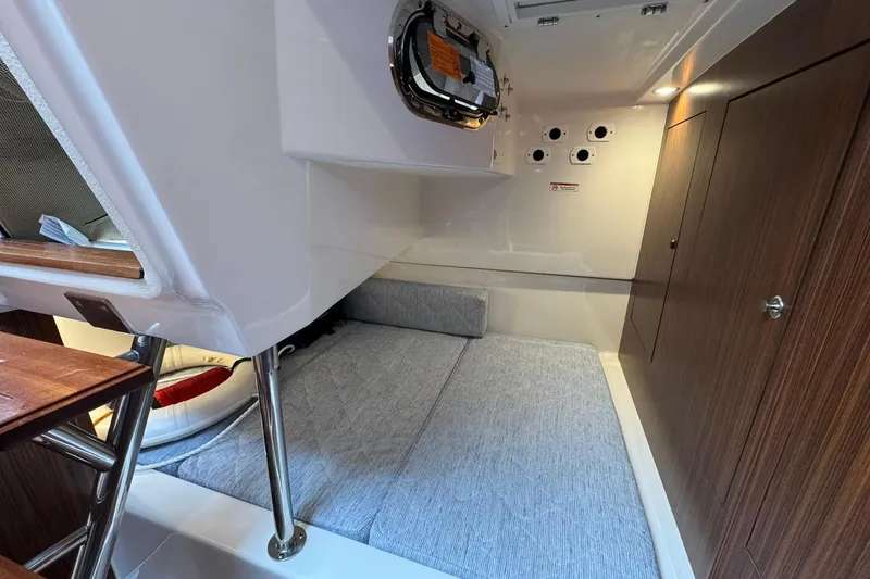 Yacht Photos Pics 2018 Pursuit OS 325 Offshore cabin interior with bed and wooden cabinetry.