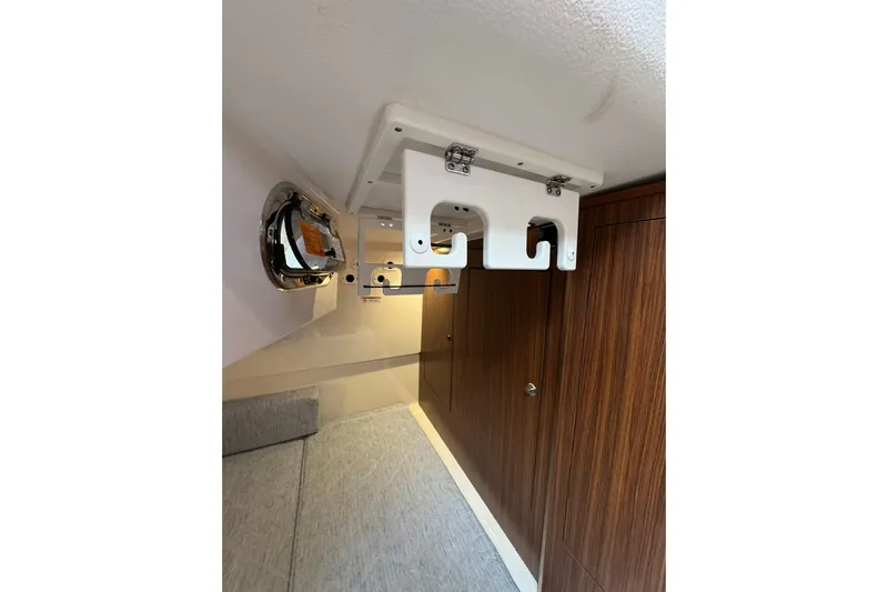  Yacht Photos Pics 2018 Pursuit OS 325 Offshore cabin interior with wood paneling and storage hooks.