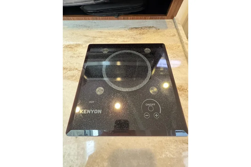  Yacht Photos Pics Kenyon cooktop on 2018 Pursuit OS 325 Offshore boat, featuring sleek design and controls.