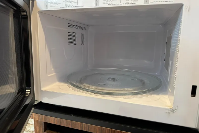  Yacht Photos Pics Empty microwave interior with glass turntable, open door, and visible control panel.