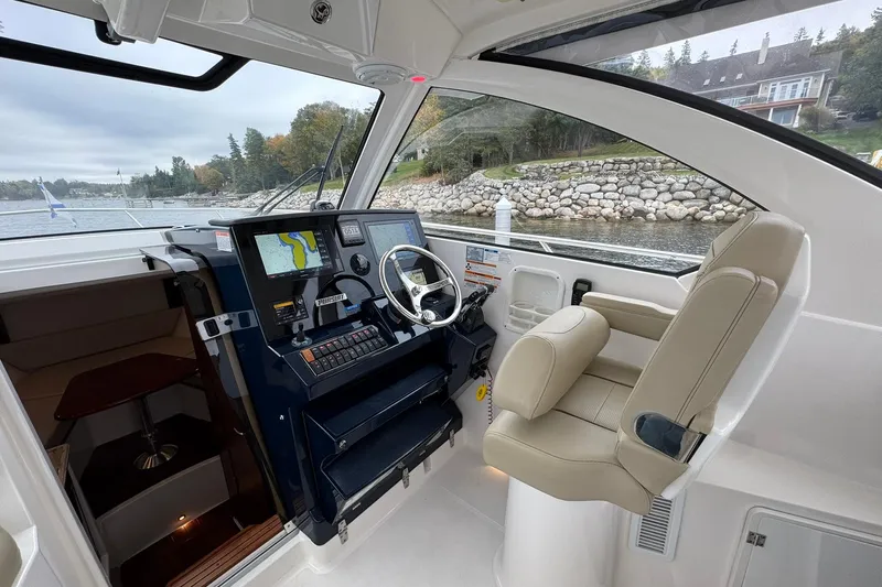  Yacht Photos Pics 2018 Pursuit OS 325 Offshore boat interior with navigation system and captain's chair.