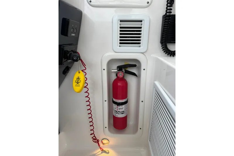  Yacht Photos Pics Fire extinguisher on 2018 Pursuit OS 325 Offshore boat, with safety equipment and controls.