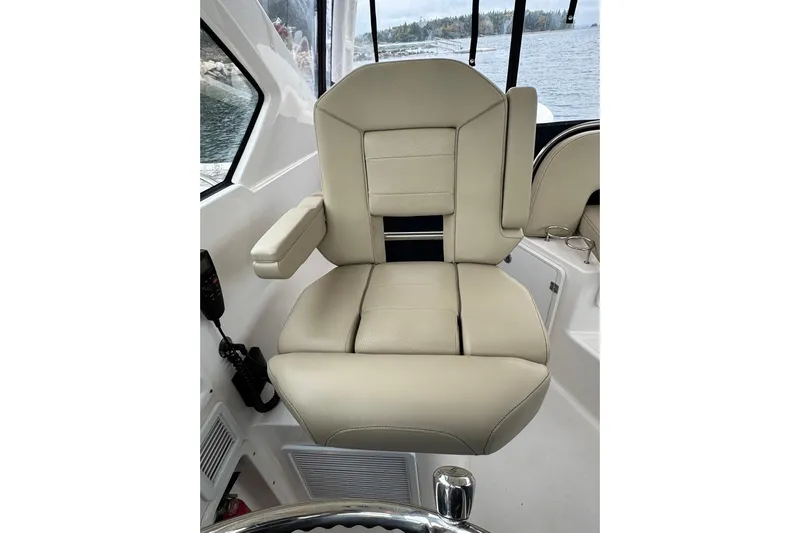  Yacht Photos Pics Captain's chair on 2018 Pursuit OS 325 Offshore boat, beige upholstery, near water.