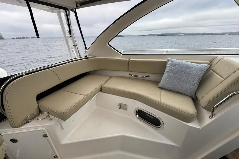  Yacht Photos Pics 2018 Pursuit OS 325 Offshore boat interior with beige seating and a blue cushion.