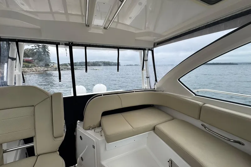 Yacht Photos Pics Interior view of 2018 Pursuit OS 325 Offshore boat with beige seating and ocean backdrop.