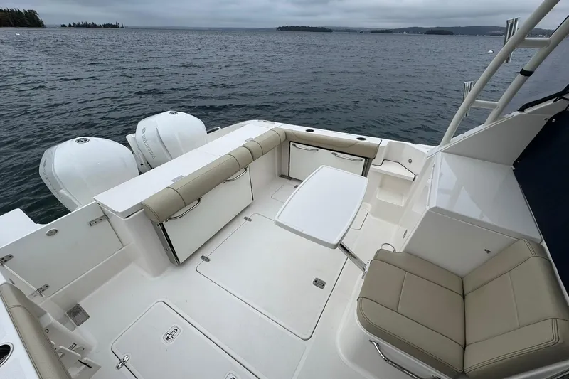  Yacht Photos Pics 2018 Pursuit OS 325 Offshore boat interior with seating and table on calm water.