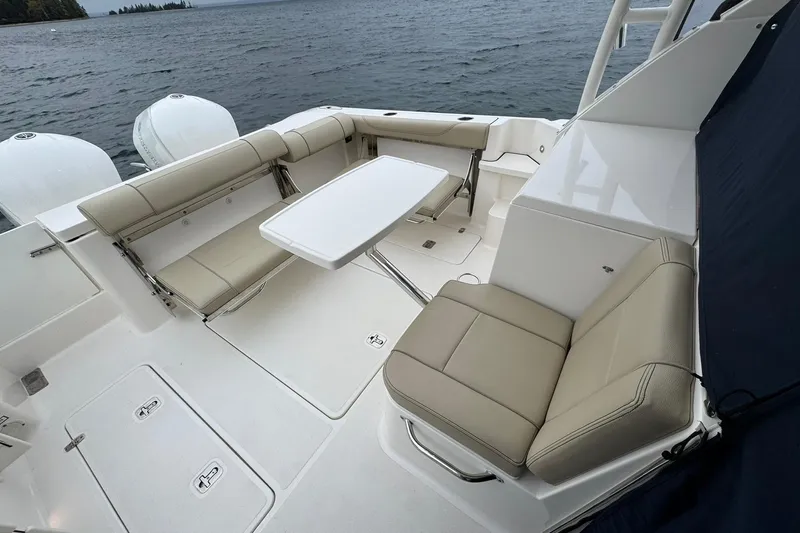 Yacht Photos Pics 2018 Pursuit OS 325 Offshore boat interior with seating and table on the water.