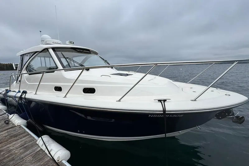  Yacht Photos Pics 2018 Pursuit OS 325 Offshore boat docked on a calm, cloudy day.