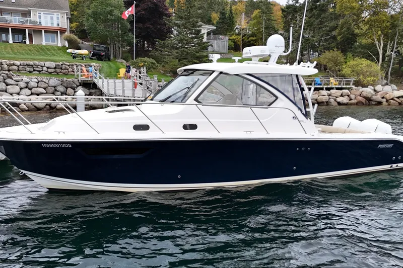  Yacht Photos Pics 2018 Pursuit OS 325 Offshore boat docked near a scenic shoreline.