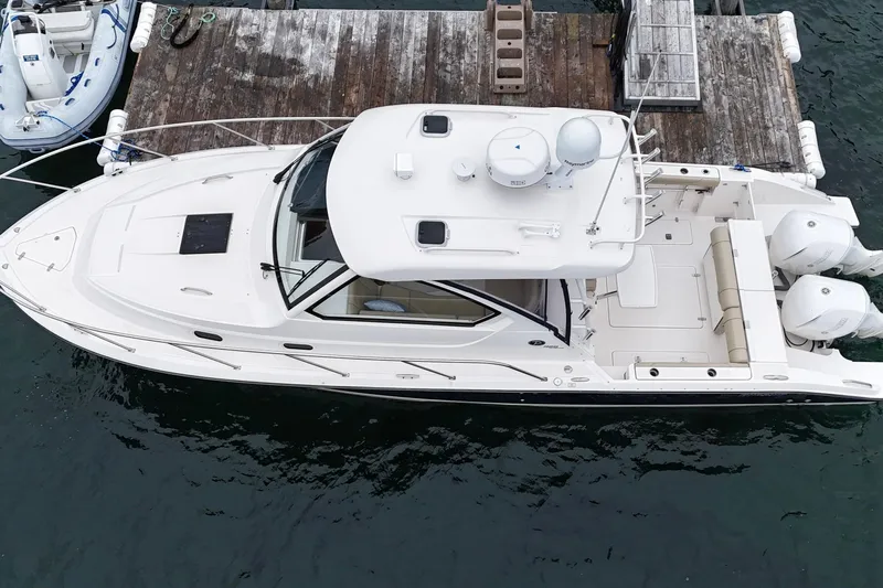 Yacht Photos Pics 2018 Pursuit OS 325 Offshore boat docked, aerial view, showcasing sleek design and twin engines.