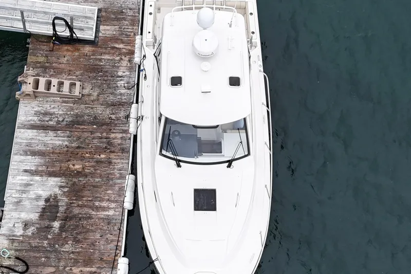  Yacht Photos Pics 2018 Pursuit OS 325 Offshore boat docked at a wooden pier, aerial view.