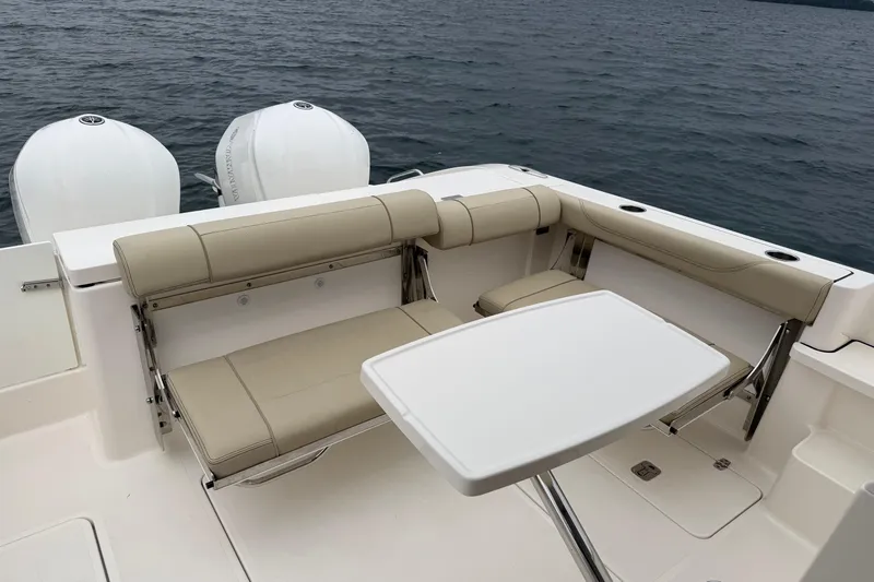  Yacht Photos Pics 2018 Pursuit OS 325 Offshore boat with beige seating and table on deck.