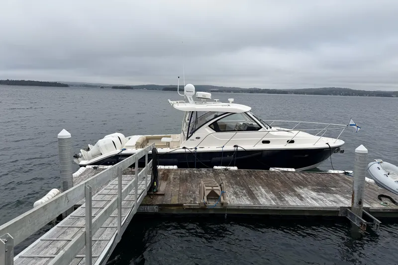  Yacht Photos Pics 2018 Pursuit OS 325 Offshore boat docked on a wooden pier, overcast sky.