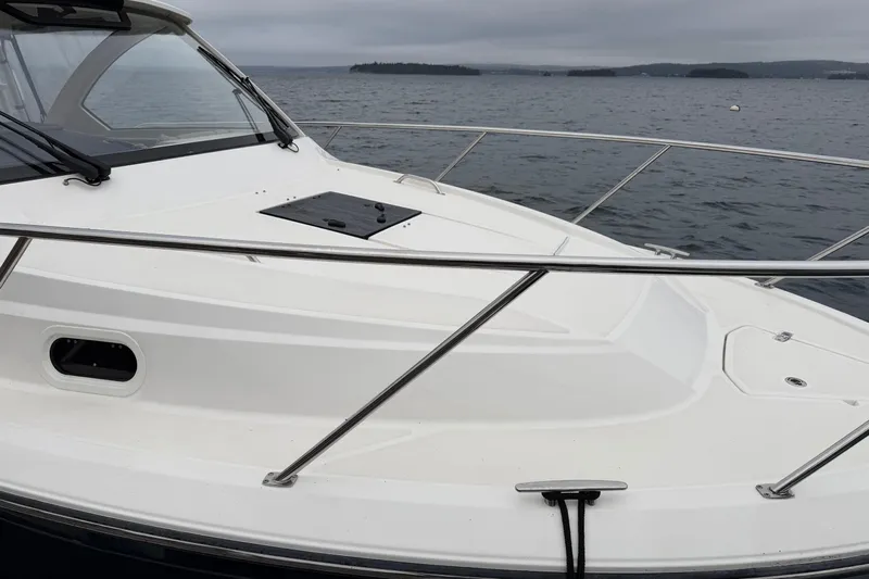  Yacht Photos Pics 2018 Pursuit OS 325 Offshore boat on calm waters, showcasing sleek design and sturdy railings.