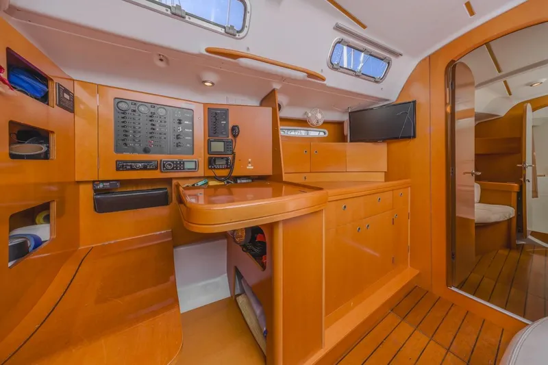 Sabbatical Yacht Photos Pics Interior of 2005 Beneteau First 44.7 yacht with navigation panel and wooden cabinetry.