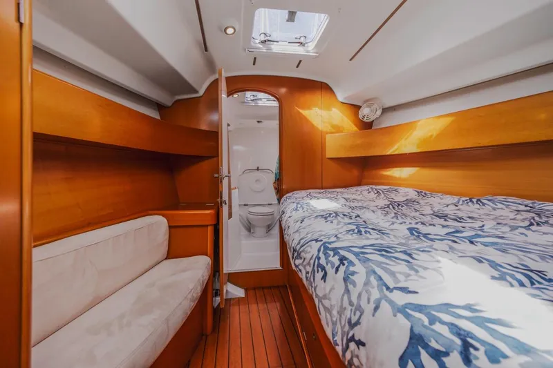 Sabbatical Yacht Photos Pics Interior of 2005 Beneteau First 44.7 yacht cabin with bed, seating, and bathroom.