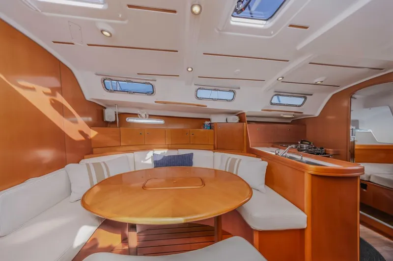 Sabbatical Yacht Photos Pics Luxurious interior of 2005 Beneteau First 44.7 yacht with elegant wood finish and seating area.