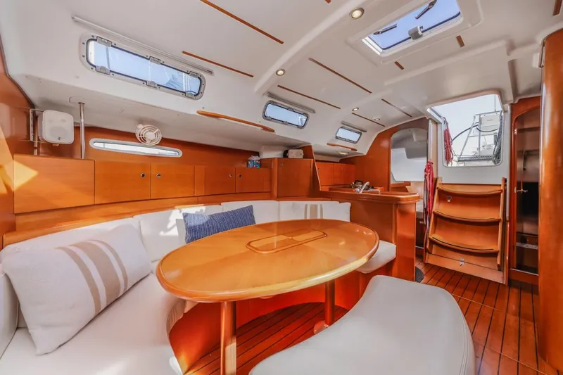 Sabbatical Yacht Photos Pics Luxurious interior of 2005 Beneteau First 44.7 yacht with elegant wood finish and seating area.