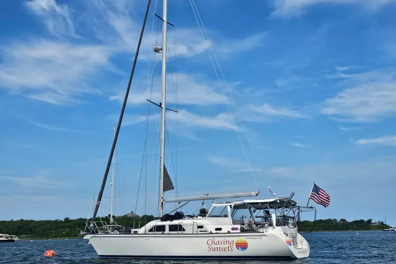  Yacht Photos Pics Sailboat "Chasing Sunsets," Catalina Morgan 440, 2005, on calm water with American flag.