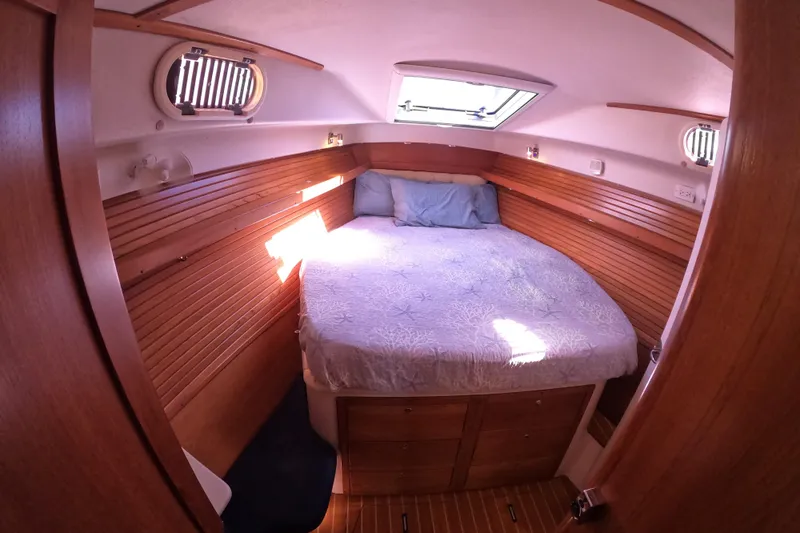  Yacht Photos Pics Cozy cabin interior of 2005 Catalina Morgan 440 sailboat with wooden paneling and bed.