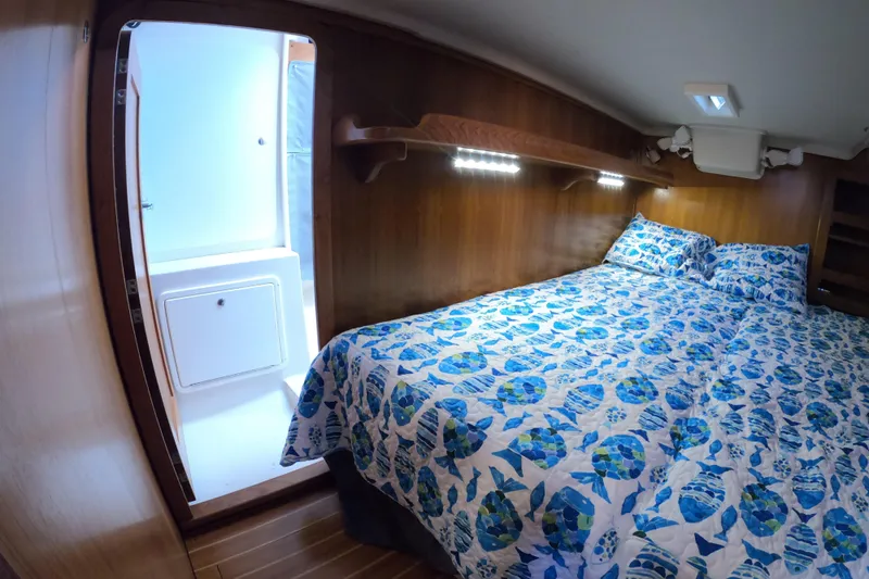  Yacht Photos Pics Cozy cabin interior of 2005 Catalina Morgan 440 yacht with blue patterned bedding.