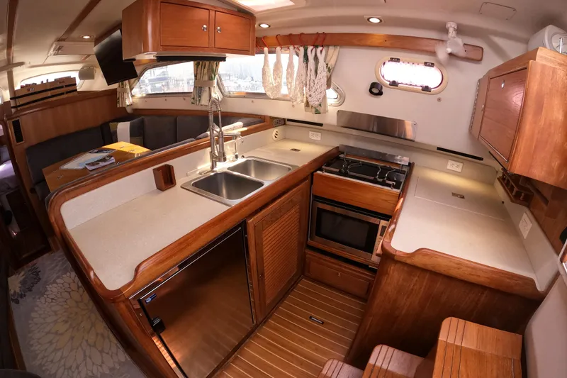  Yacht Photos Pics Luxurious 2005 Catalina Morgan 440 yacht interior with modern kitchen and wooden cabinetry.