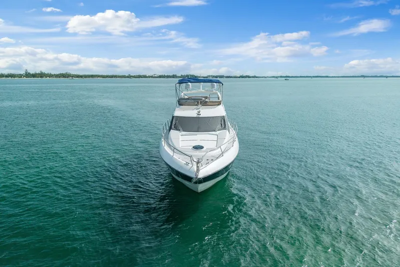  Yacht Photos Pics 2006 Sunseeker Manhattan 50 yacht on calm turquoise waters under a clear blue sky.