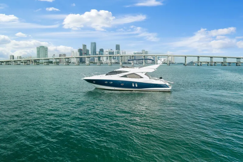  Yacht Photos Pics 2006 Sunseeker Manhattan 50 yacht cruising near city skyline and bridge.