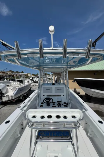  Yacht Photos Pics 2024 Contender 28 Tournament boat with sleek console and rod holders, docked under clear blue sky.