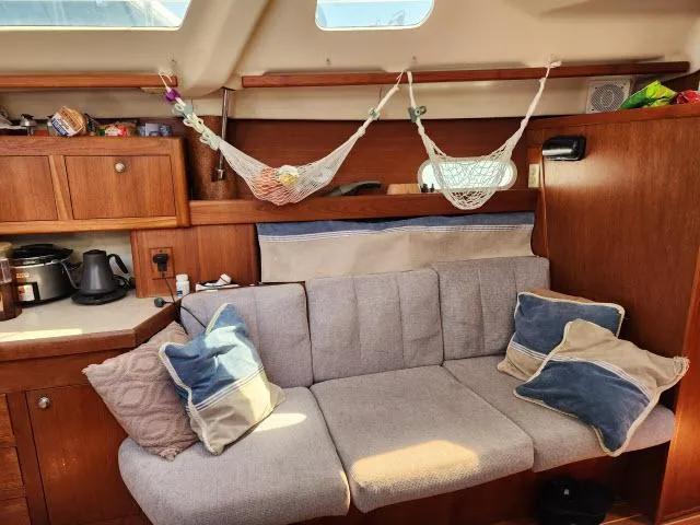 Plan B Yacht Photos Pics Cozy interior of 1998 Hunter 450 Passage sailboat with cushions and hanging storage.
