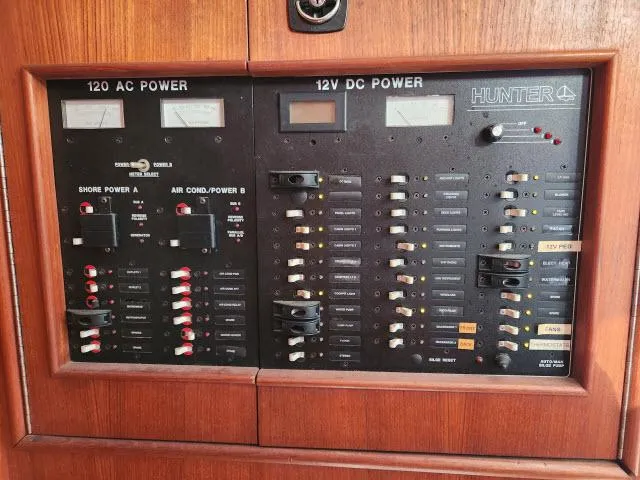 Plan B Yacht Photos Pics Electrical control panel of a 1998 Hunter 450 Passage yacht, featuring AC and DC power switches.