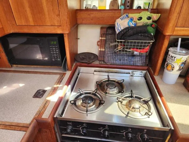 Plan B Yacht Photos Pics Compact kitchen in 1998 Hunter 450 Passage yacht with stove, microwave, and storage.