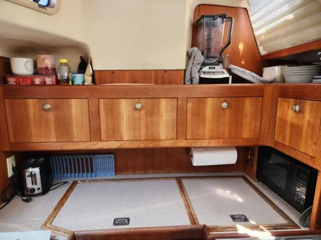 Plan B Yacht Photos Pics Kitchen area of a 1998 Hunter 450 Passage sailboat with wooden cabinets and appliances.