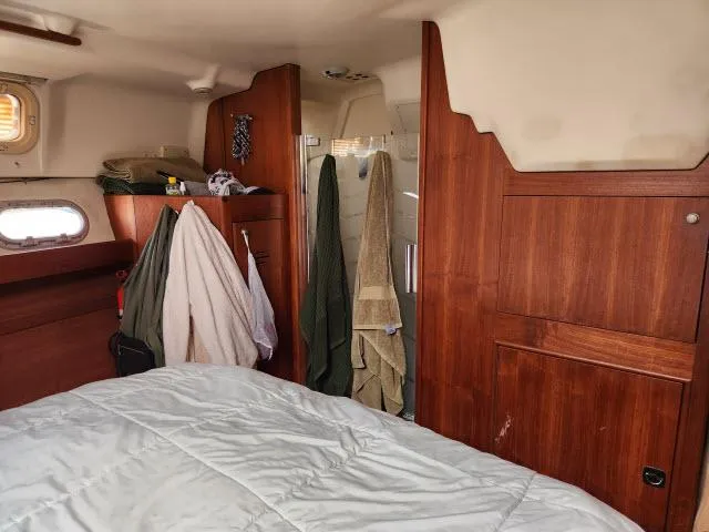 Plan B Yacht Photos Pics Cozy cabin interior of 1998 Hunter 450 Passage sailboat with wooden paneling and bed.