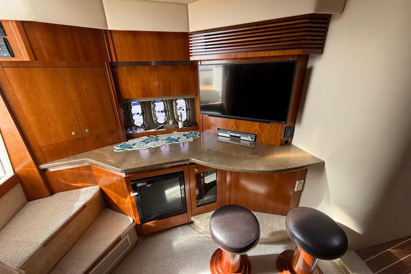  Yacht Photos Pics Luxurious 2008 Cruisers Yachts 420 Express interior with TV, bar stools, and wooden cabinetry.